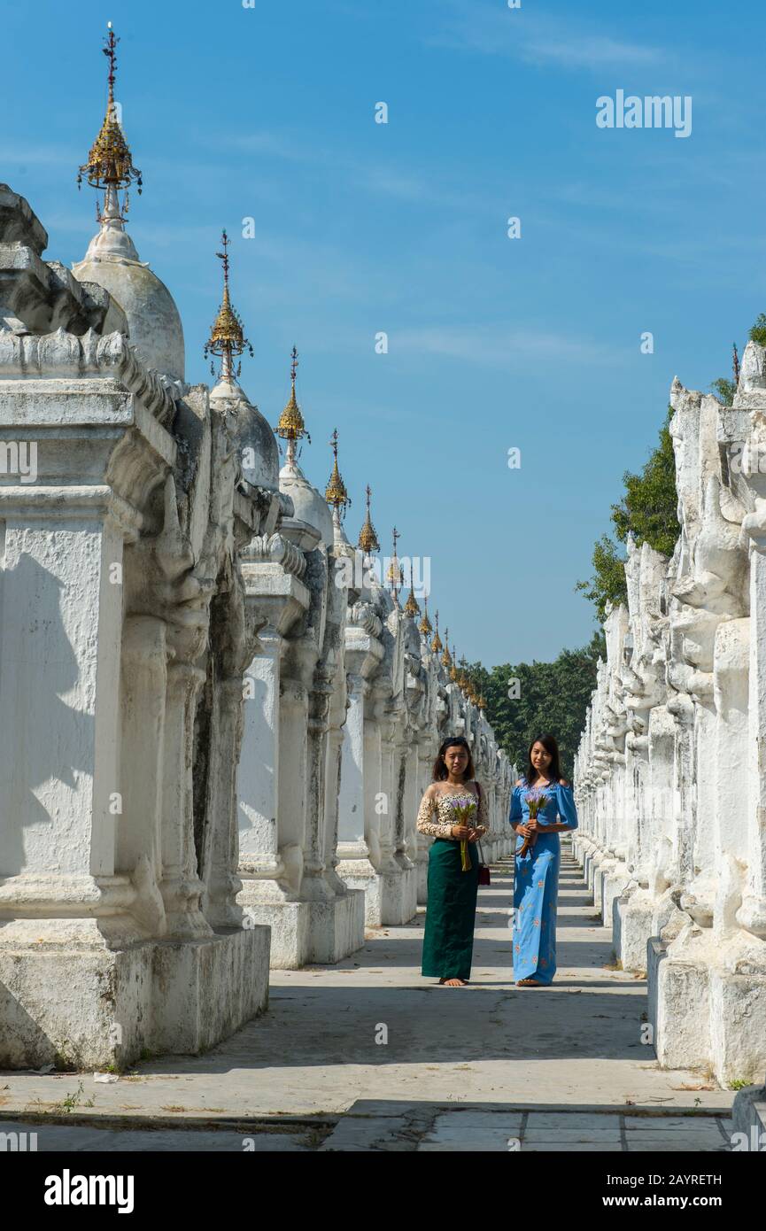 Zwei junge Frauen in den Stupas-Reihen, die jeweils eine der 729 Platten mit den buddhistischen Lehren in der Kuthodaw-Pagode auf Mandalay unterbringen Stockfoto