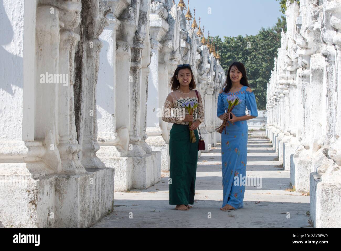Zwei junge Frauen in den Stupas-Reihen, die jeweils eine der 729 Platten mit den buddhistischen Lehren in der Kuthodaw-Pagode auf Mandalay unterbringen Stockfoto