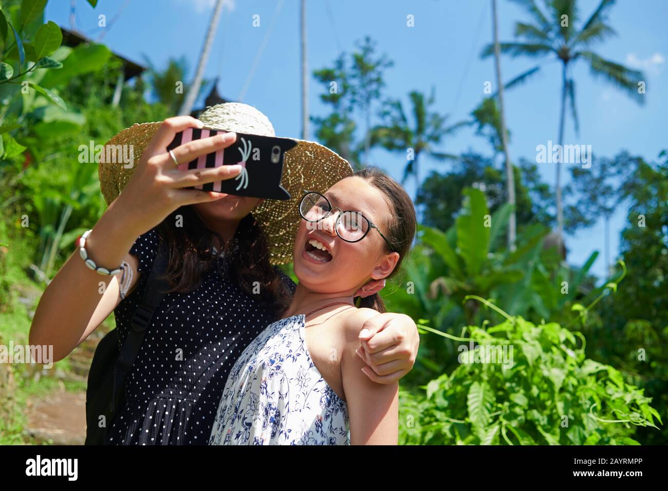 Zwei niedliche Teenager-Schwestern, die Selfies zusammen nehmen und dabei viel Spaß haben, sich vor der Kamera zu posieren Stockfoto