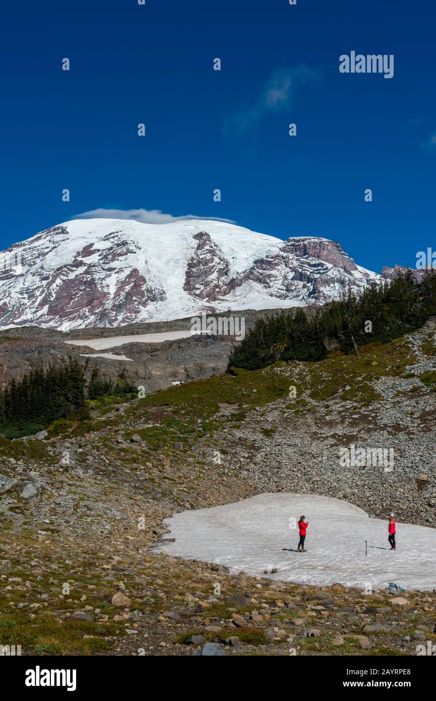Blick vom Skyline Trail des Mount Rainier mit Wanderern auf einem Schneefeld in Mt. Rainier National Park im US-Bundesstaat Washington. Stockfoto