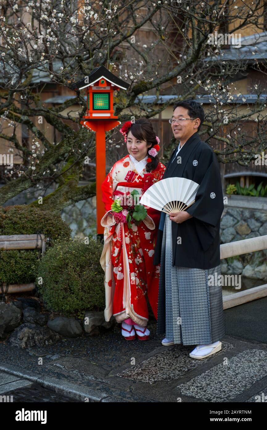 Ein Hochzeitspaar posiert an einer Lampe am Shirakawa-Kanal im Gion-Viertel in Kyoto, Japan. Stockfoto