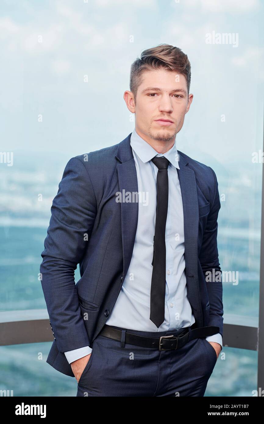 Portrait eines gutaussehenden jungen Geschäftsmannes im formellen Anzug, der sich vor der Kamera posiert Stockfoto