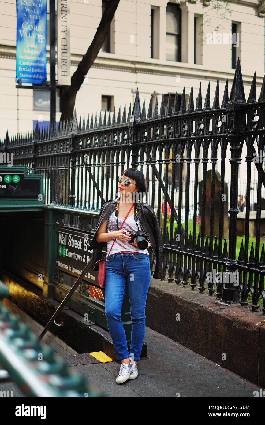 Asian Woman Tourist am U-Bahn-Eingang der Wall Street in der Nähe der Trinity Church Lower Manhattan, New York City Stockfoto