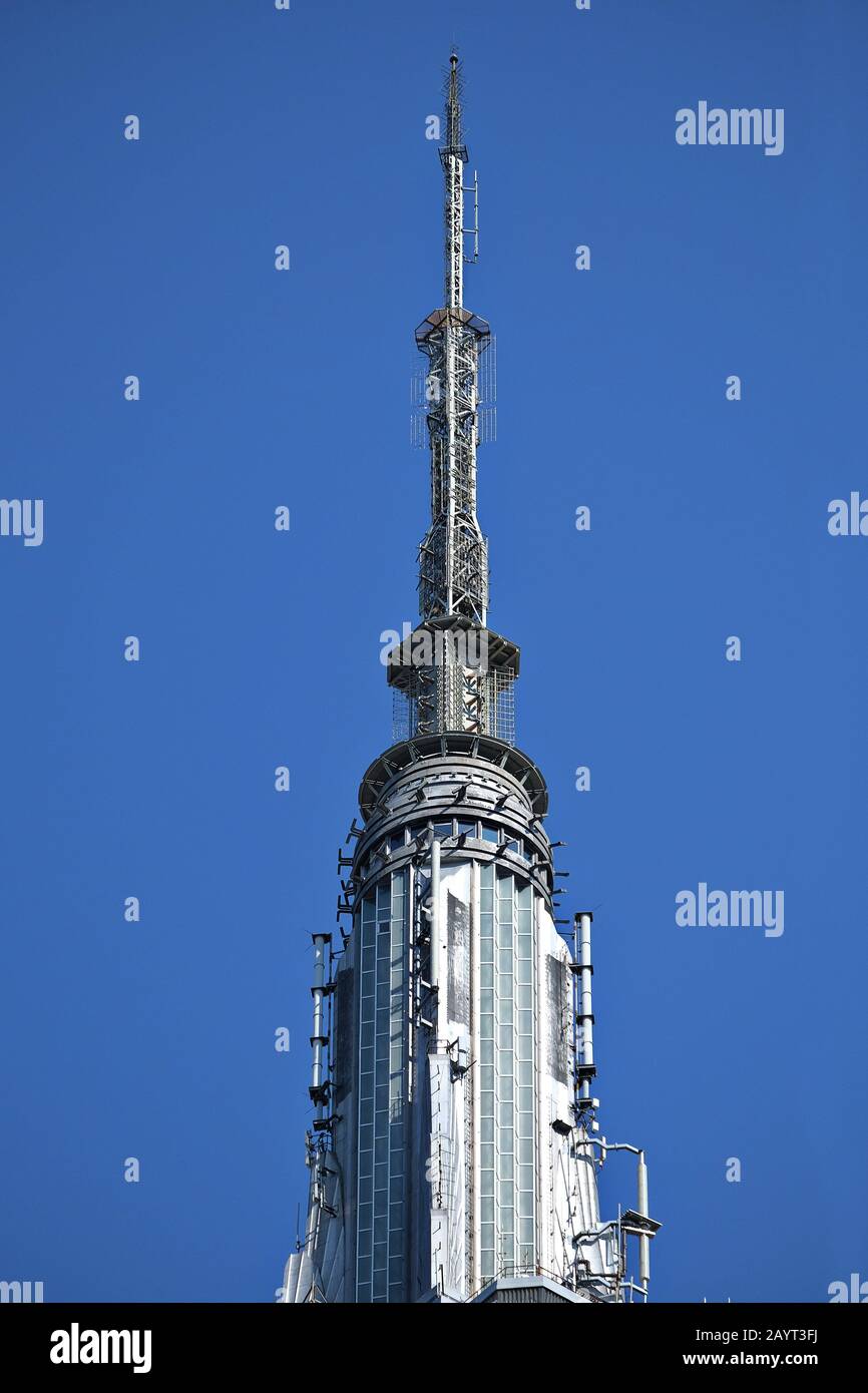 Oben auf dem Mast, oben auf dem Empire State Building ein Blick aus nächster Nähe auf den Art déco-Wolkenkratzer in Midtown Manhattan, New York, mit langer Linse Stockfoto