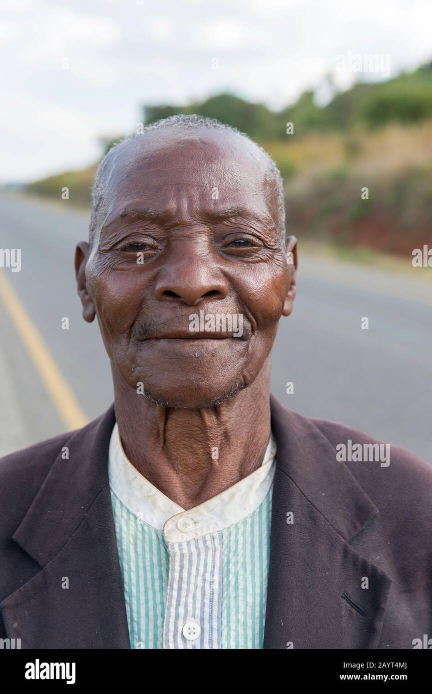 Porträt eines malawischen Mannes, der auf der Straße von Blantyre nach Zomba in Malawi spazieren geht. Stockfoto