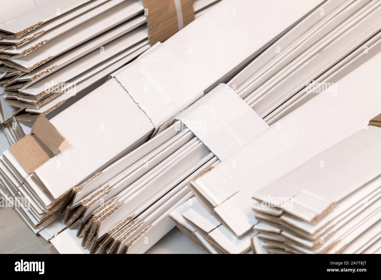 Gestapelte, gefaltete weiße Pappkartons, Hintergrundfoto für Industrieverpackungen Stockfoto