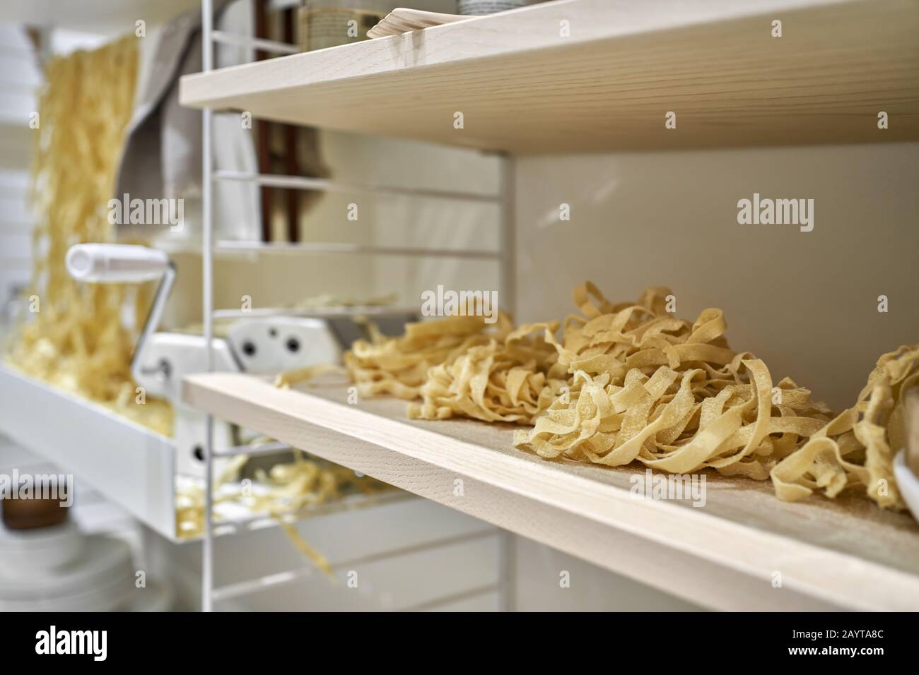 Viele rohe Nudeln mit Nudelmaschine im Innenbereich Stockfoto