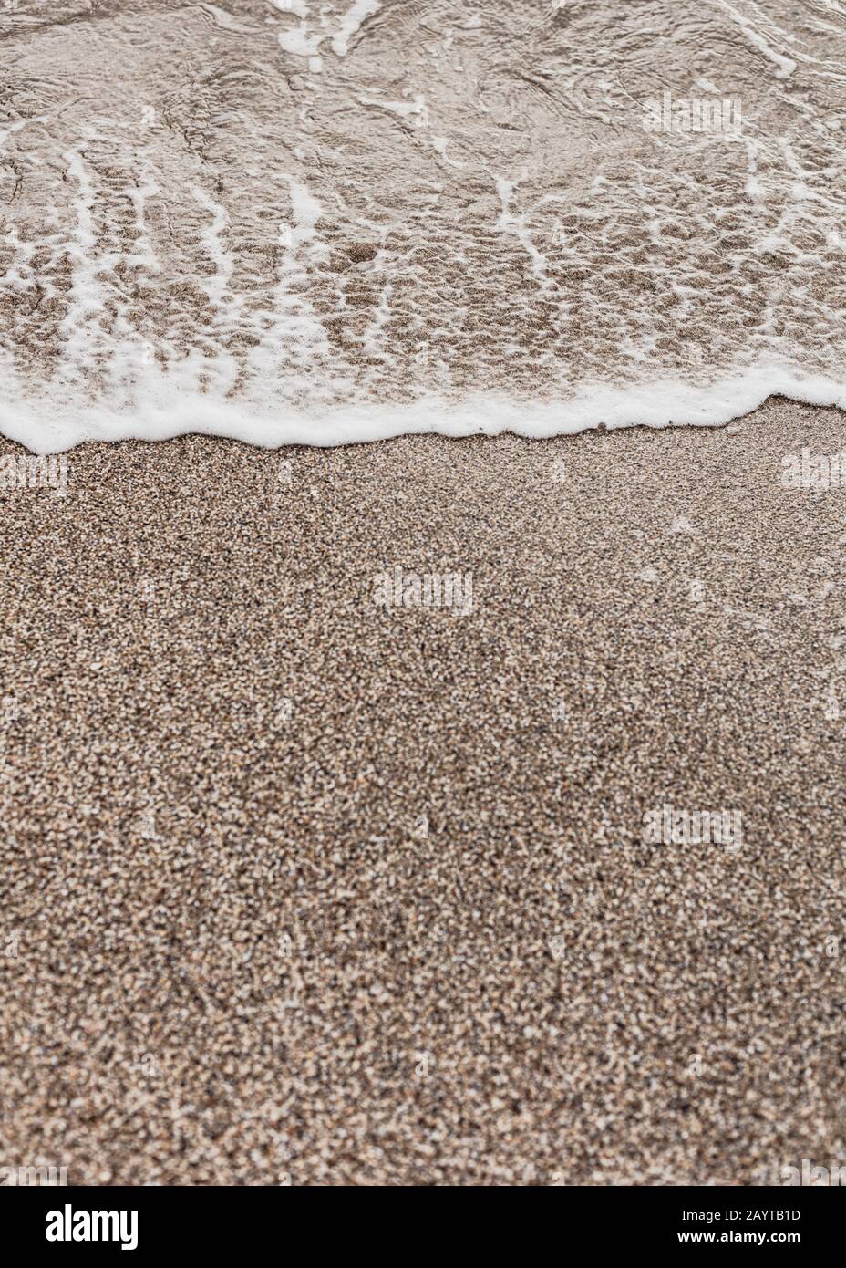 Verschiedene Struktur am Strand - Wasser und Sand, Steine und Kiesel, Wellen und Spritzer. Selektiver Fokus. Stockfoto