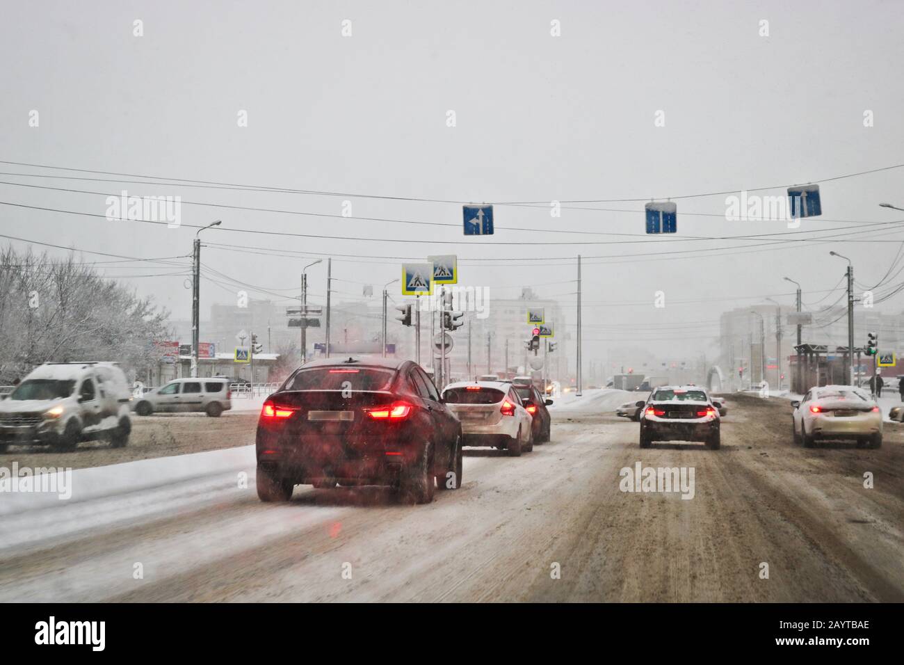 Blick vom Autofenster bei Regen und nassem Schnee. Schlechte Sicht beim Fahren in der Stadt. Verschneite Straße. Stockfoto