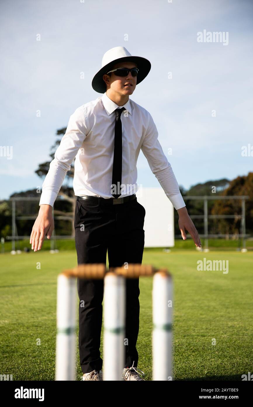 Cricket-Schiedsrichter, der auf einem Cricket-Platz steht Stockfoto