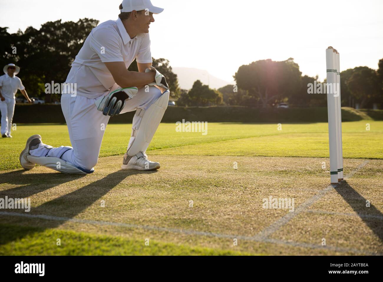 Cricket-Spieler lächeln und beobachten das Spiel Stockfoto