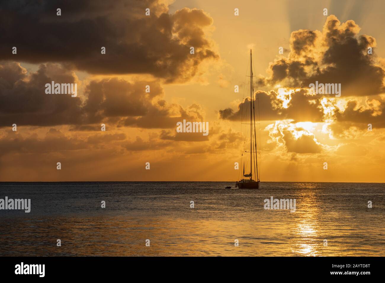 Blick auf den Sonnenuntergang auf die Yacht, die in der Lagune, der Bucht von Britannia, der Insel Mustique, Saint Vincent und die Grenadinen, dem karibischen Meer, verankert ist Stockfoto