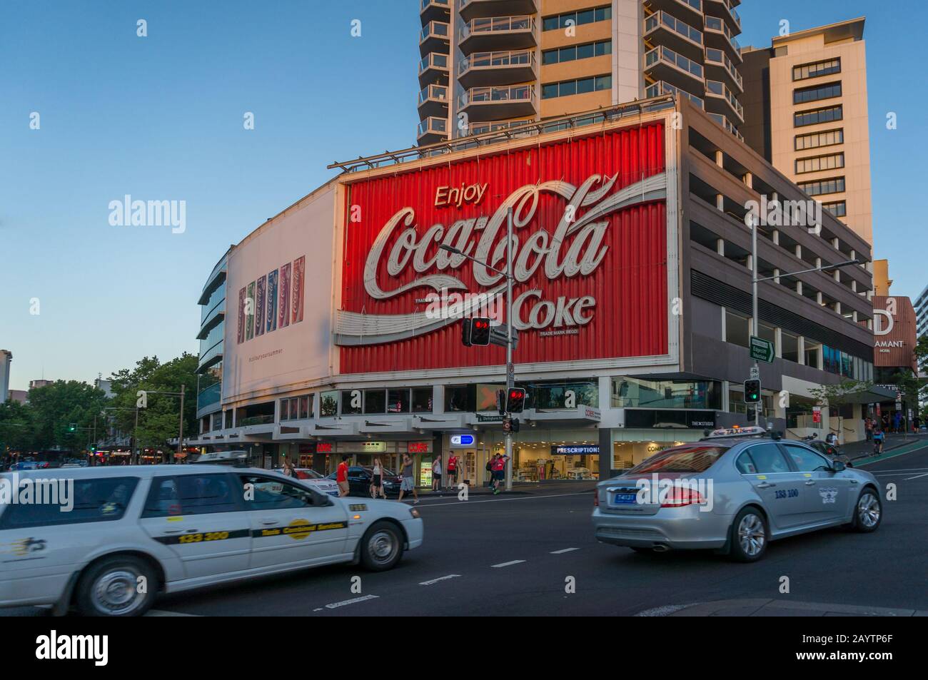 Sydney, Australien - 12. November 2014: Berühmte Coca-Cola-Werbung auf einem Gebäude im Kings Cross Vorort von Sydney mit Abendverkehr Stockfoto