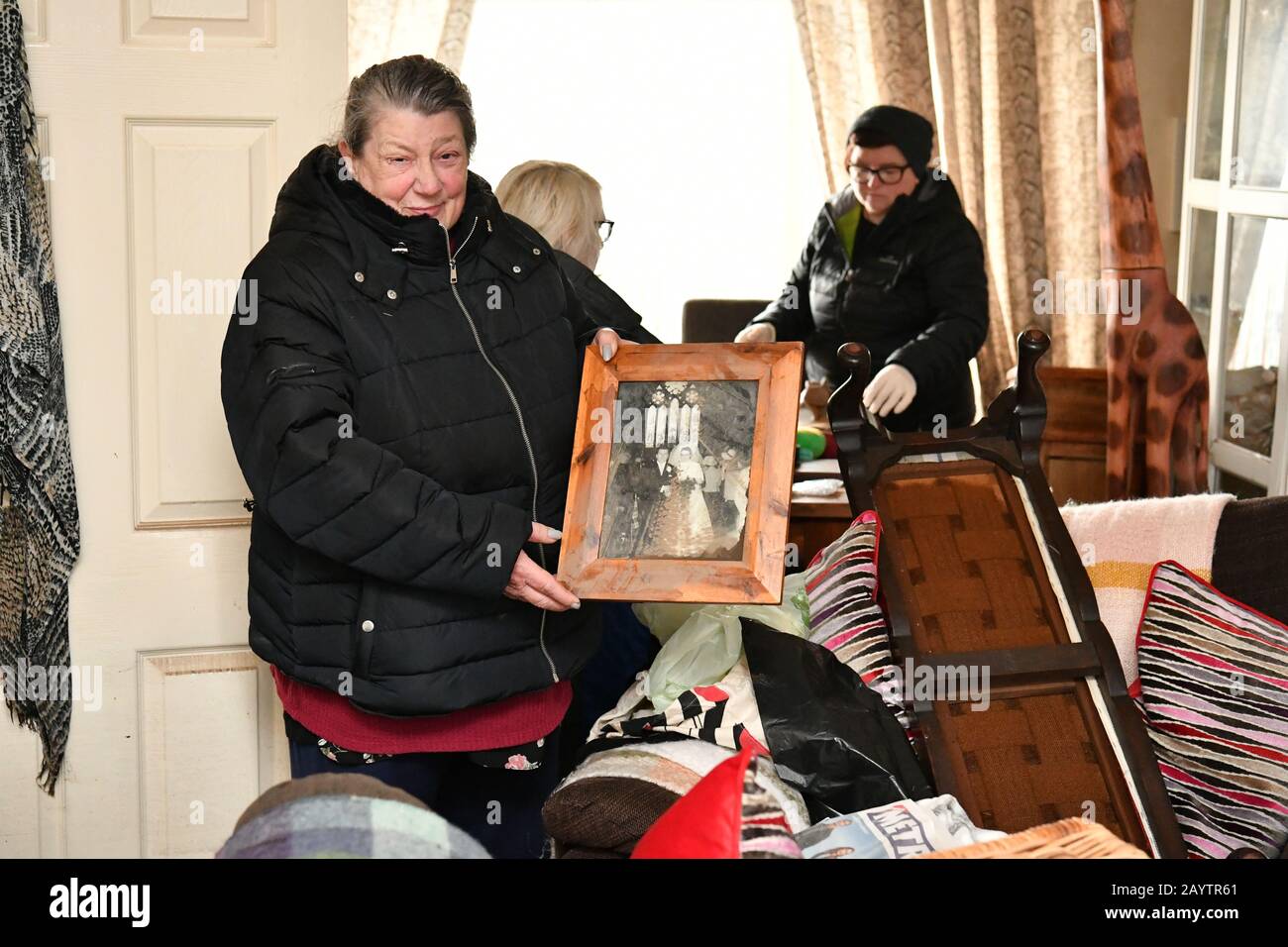 Janette Cox, 68, hielt ihr gespeichertes Hochzeitsfoto von 1971 ihres verstorbenen Ehemannes Bill, der vor 9 Jahren vergangen war, in der 37 Oxford Street, Nantgarw, in Südwales, wo die Bewohner in ihre Häuser zurückkehren, um die Schäden nach dem Sturm Dennis zu untersuchen und zu beheben. Stockfoto