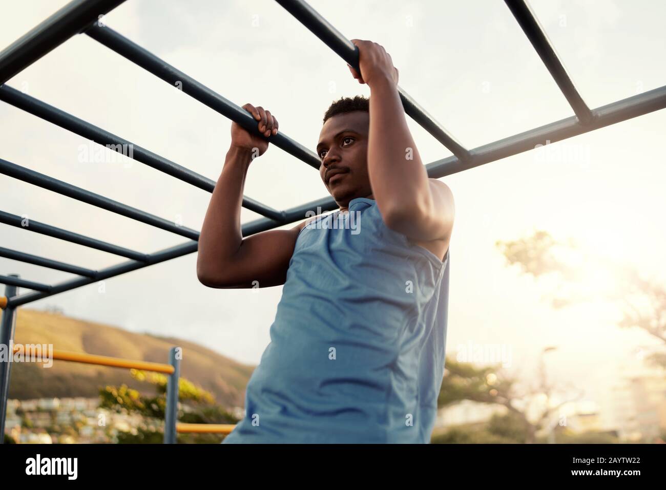 Muskulöse junge athletische Passform afrikanamerikanischer Mann, der in einem Outdoor-Fitnessstudio ausarbeitet, um Pull-Ups zu machen Stockfoto