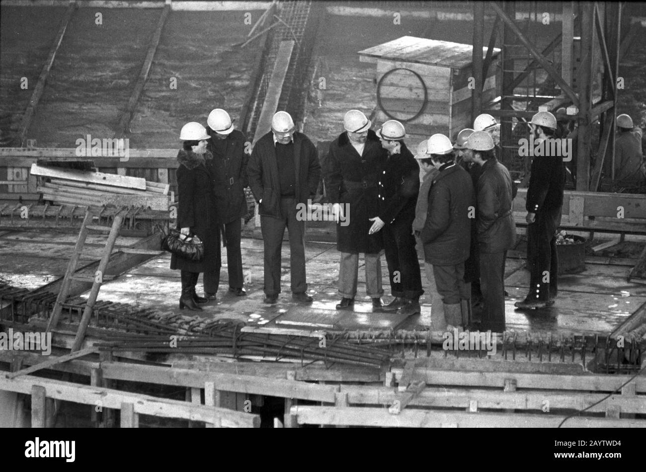 01. Januar 1979, Sachsen, Leipzig: Ende der 1970er Jahre besuchte der Gewandhausbandmeister Kurt Masur (4. Von links) in Begleitung von Baustellenleitern und Bauarbeitern die Baustelle des neuen Gewandhauses in Leipzig am Karl-Marx-Platz und hinterließ vermutlich Schuhdrucke in Frischbeton. Zu seiner Rechten ist Bauleiter Peter Kunze. Genaues Aufnahmedatum nicht bekannt. Foto: Volkmar Heinz / dpa-Zentralbild / ZB Stockfoto