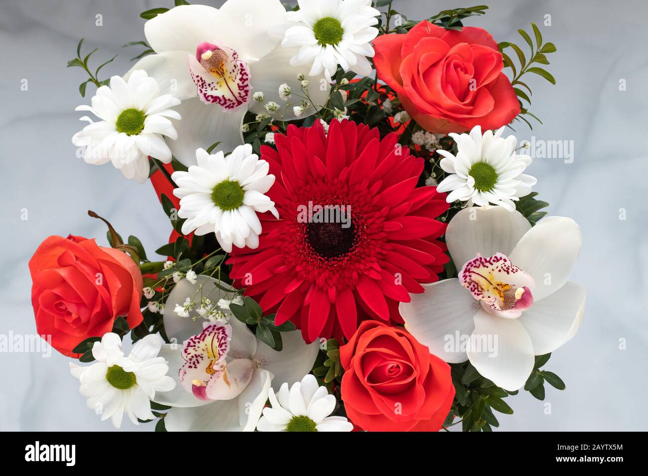 Blumenstrauß mit bunten Blumen Draufsicht auf grauem Hintergrund. Geschenkgutschein mit Kunstflorett, Naturmuster Stockfoto