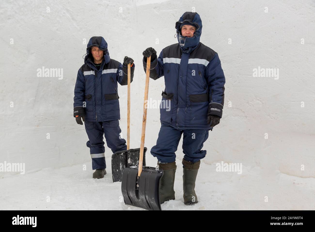 Zwei Arbeiter in blauen Jacken zur Schneeräumung Stockfoto