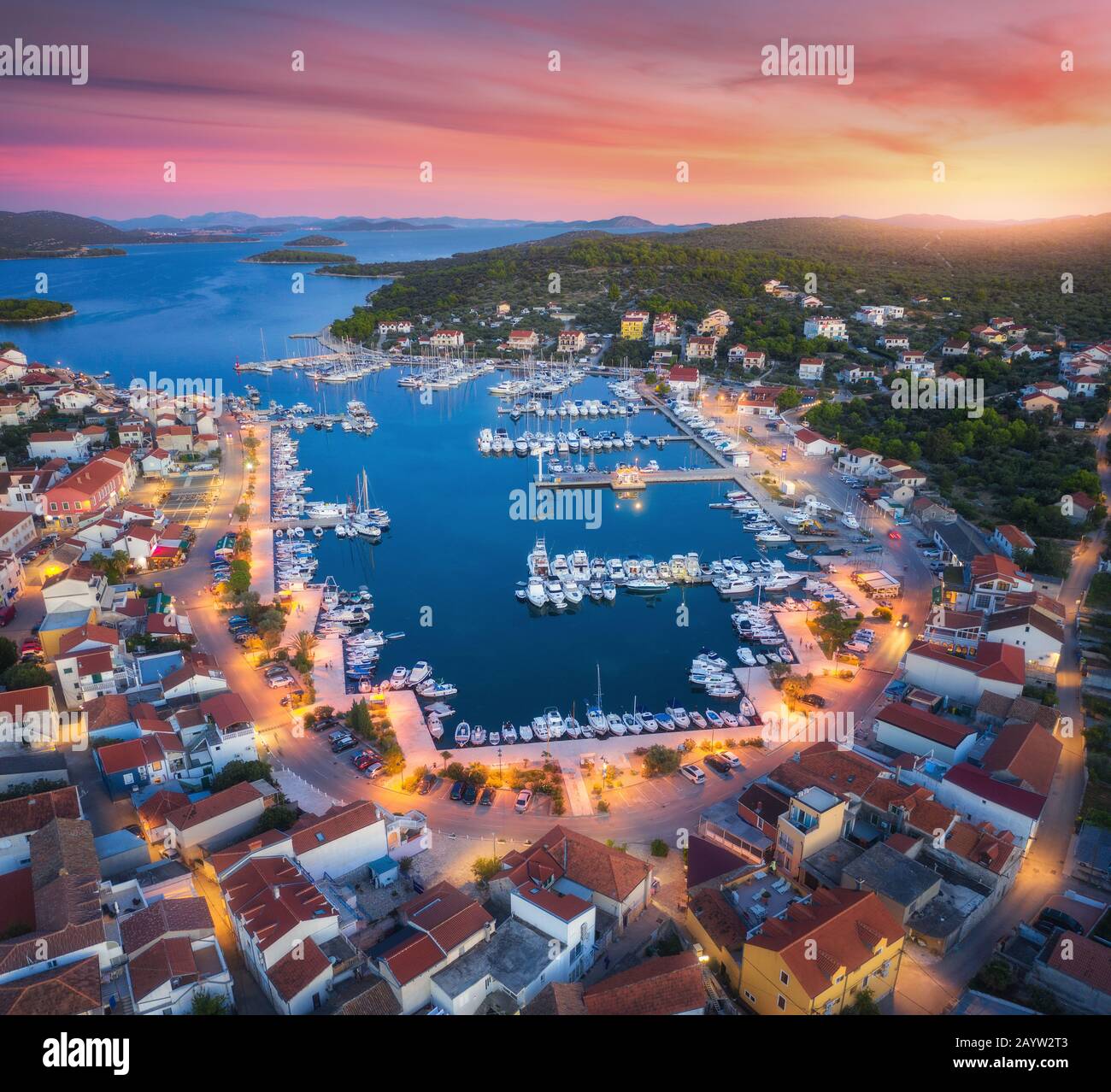 Luftansicht von Booten und Yachten in Hafen und Stadt bei Sonnenuntergang Stockfoto