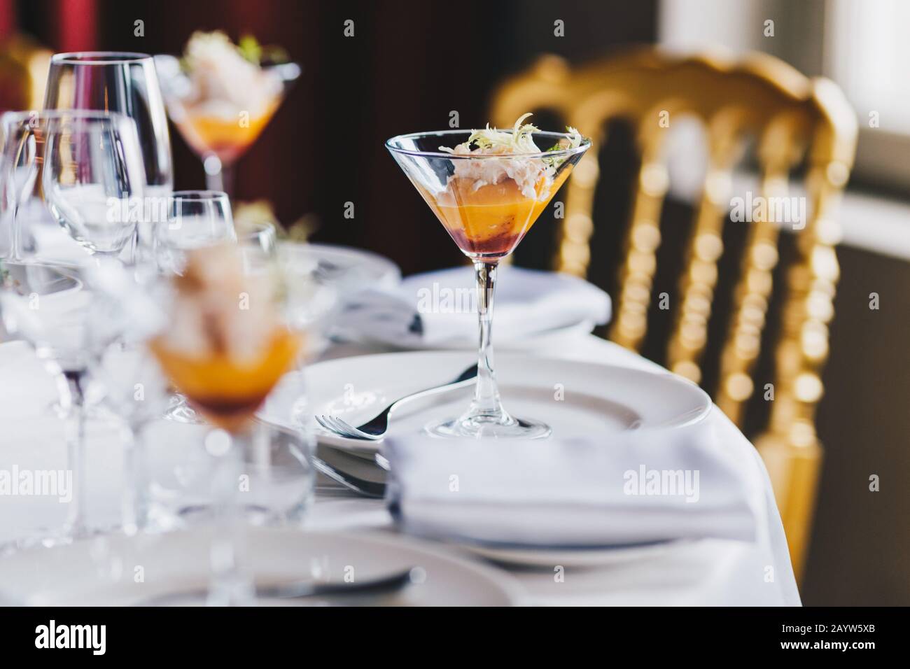 Nahansicht des festlich dekorierten Tisches mit teurem Besteck, Glas alkoholischem Cocktail. Tischeinstellung mit Dekor. Oragnisierte Firmenparty. Mi Stockfoto