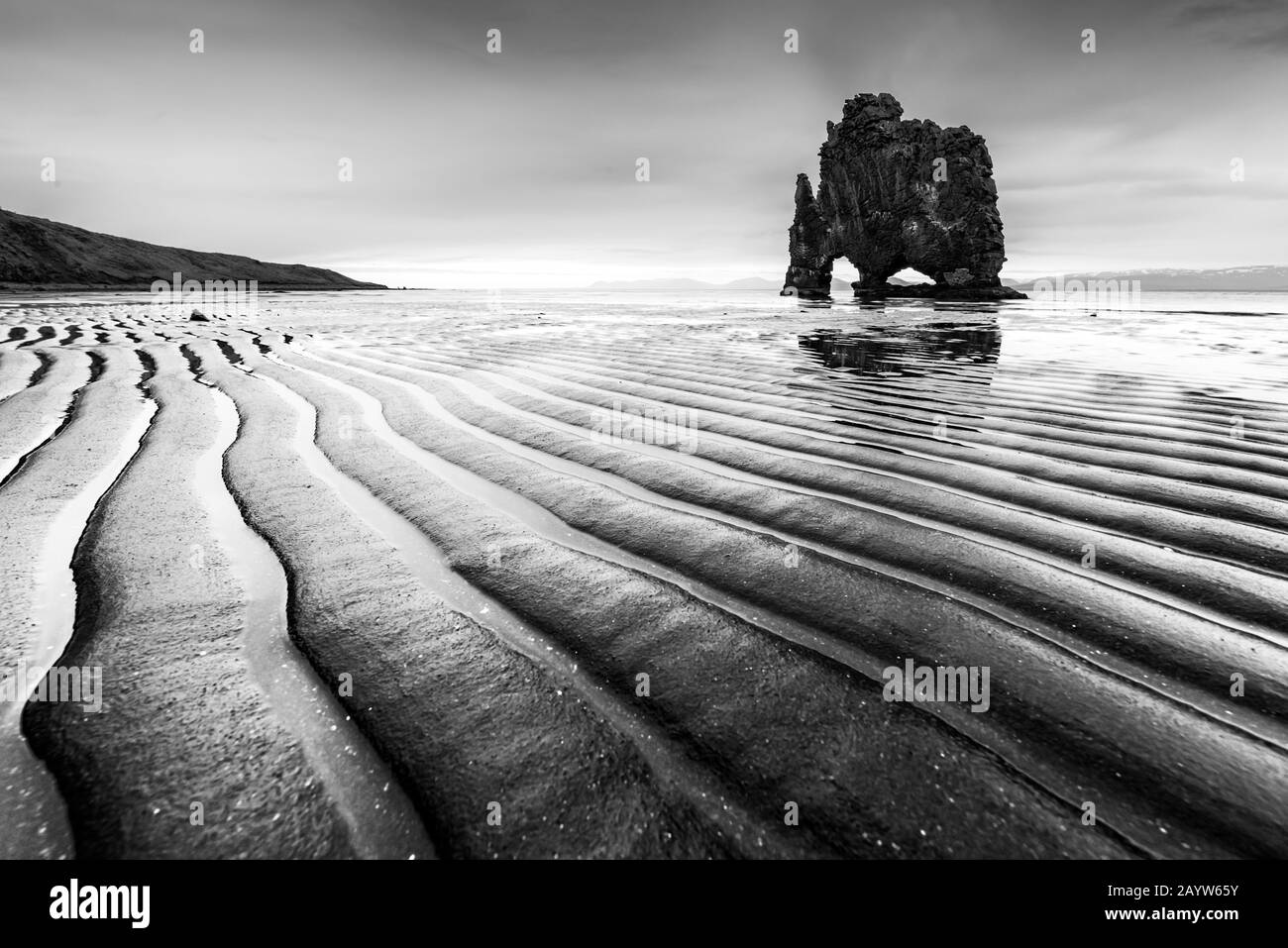 Drammatische Landschaft mit berühmtem Hvitserkur Felsen und dunklem gewelltem Sand nach der Flut. Halbinsel Vatnsnes, Island, Europa. Schwarzweißfoto Stockfoto