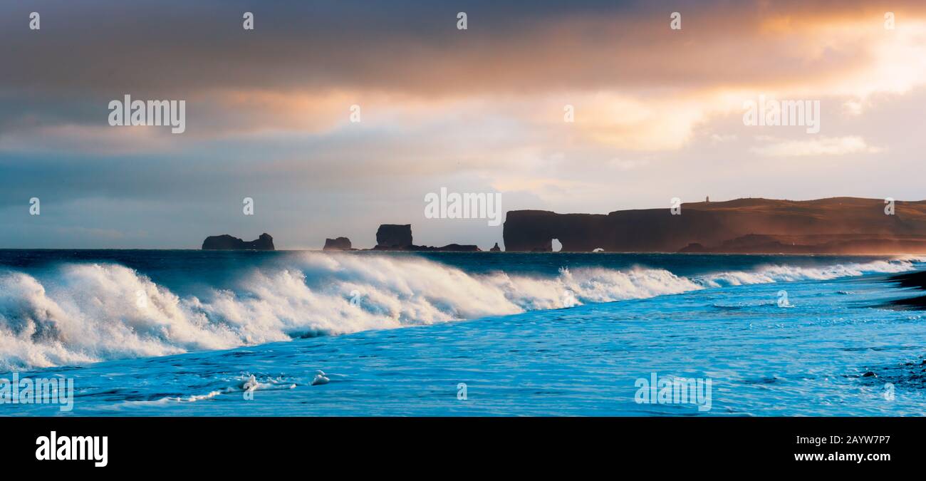 Wunderschöne Panoramalandschaft mit großen Wellen am Schwarzen Strand. Stürmische Wellen des Atlantiks und eine Wolkenlandschaft. Reynisdrangar, Vik, Island Stockfoto