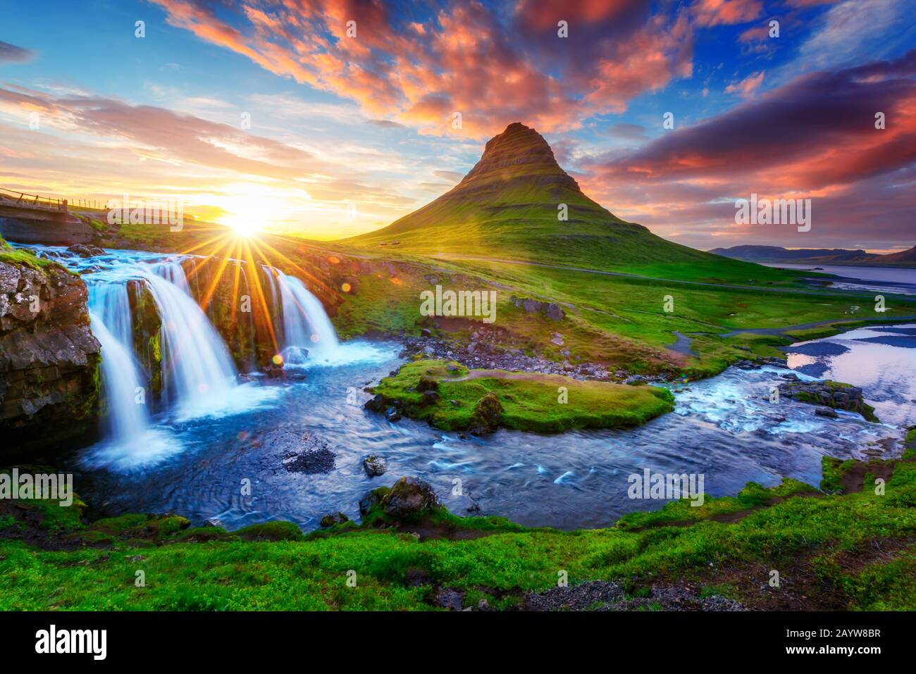 Wunderschöne Landschaft mit aufsteigender Sonne am Wasserfall Kirkjufellsfoss und am Berg Kirkjufell, Island, Europa. Stockfoto