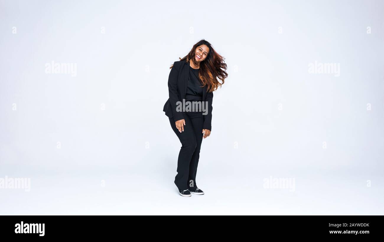 Lächelnde Geschäftsfrau steht isoliert auf weißem Hintergrund. Fröhliche Frau in formeller Kleidung mit Blick auf die Kamera. Stockfoto