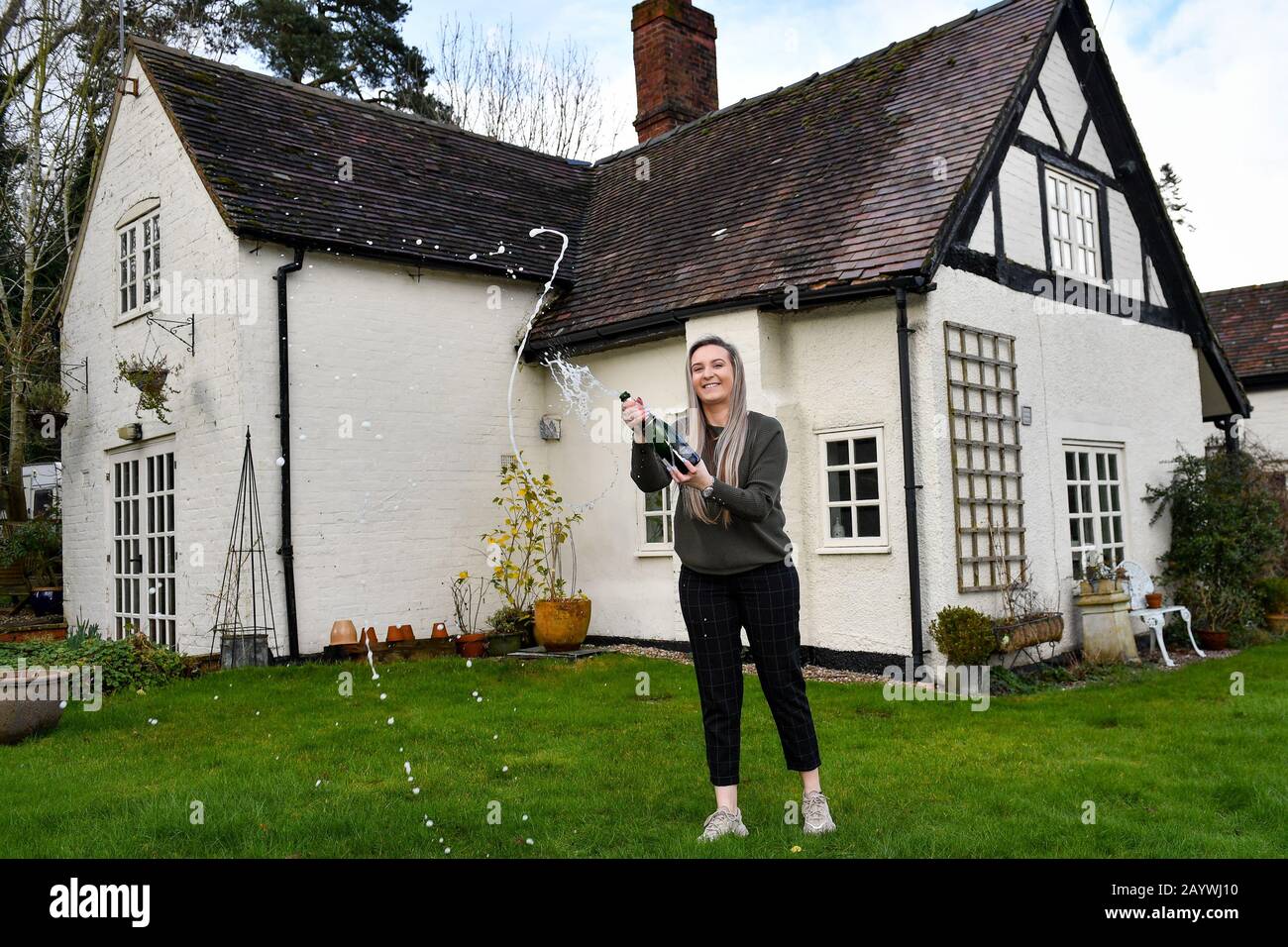 Jemma Nicklin, 23, feiert mit einer Flasche Champagner bei ihrem ersten Besuch der Sträubbery Farm in Longnor bei Shrewsbury, einem 300 Jahre alten Bauernhaus mit vier Schlafzimmern, das sie gewann, nachdem sie zwei £2 Tickets in einer Tombola gekauft hatte, die von Besitzer Mike Chatha organisiert wurde. Stockfoto