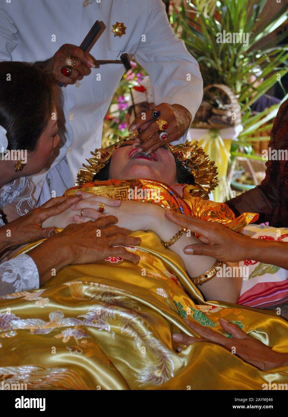 Eine balinesische Frau steht auf einem Schneidezahnritual. Das Schneiden von Zähnen ist ein traditionelles balinesisches Ritual als Zeichen für eine balinesische Frauenreife. Stockfoto