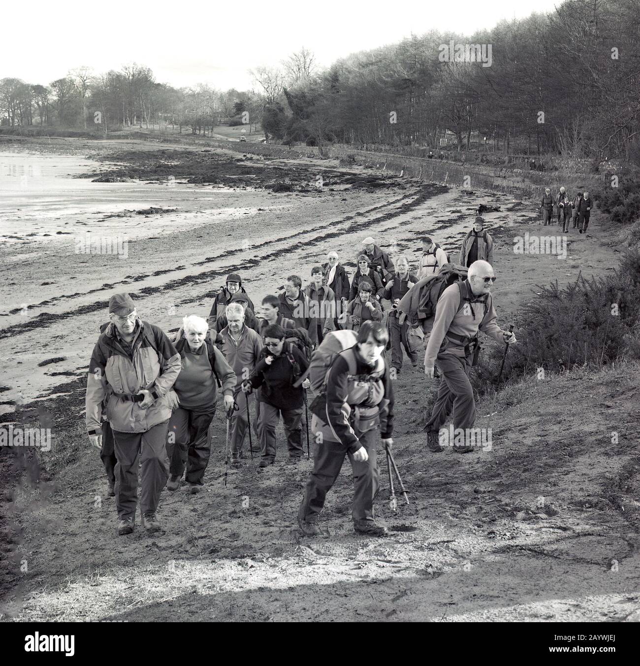 1980er Jahre, eine Gruppe von erwachsenen Wanderern oder Wanderern in Schutzkleidung im Freien, die an der Bucht des Flusses Entlang der Forth Bridge, Stirling, Schottland, spazieren gehen. Stockfoto