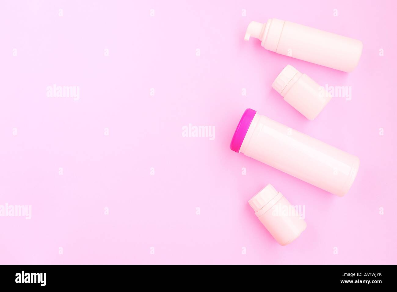 Pinkfarbene Kunststoffflaschen. Kosmetikprodukte für Frauen. Flaches Layout, Kopierbereich. Stockfoto