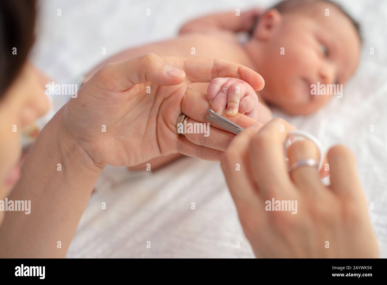 Baby, Fingernägel schneiden, während seine Mutter mit einer Schere zu schlafen. Pflege ein Kind. Stockfoto