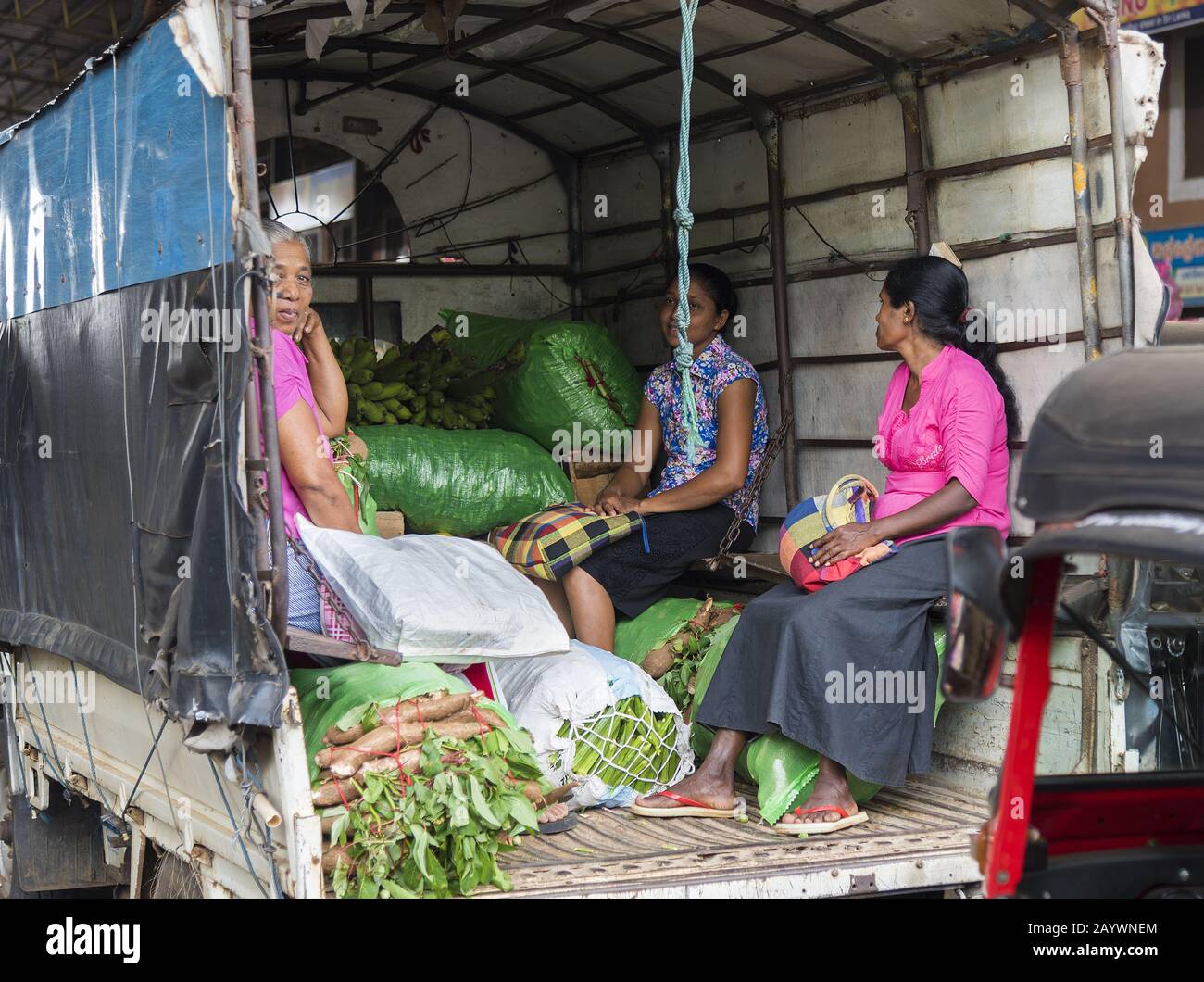 Dambulla, Sri Lanka: 18.03.2019: Frauen auf dem Gemüsemarkt im Großhandel sitzen im Heck eines LKWs mit Säcken vegatbarer Produkte. Stockfoto