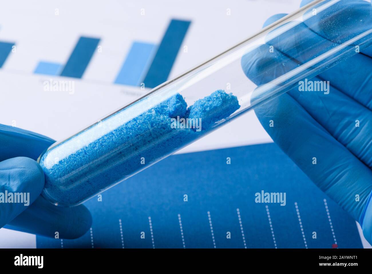 Wissenschaftler halten Reagenzglas mit blauen Kristallen im Labor Stockfoto