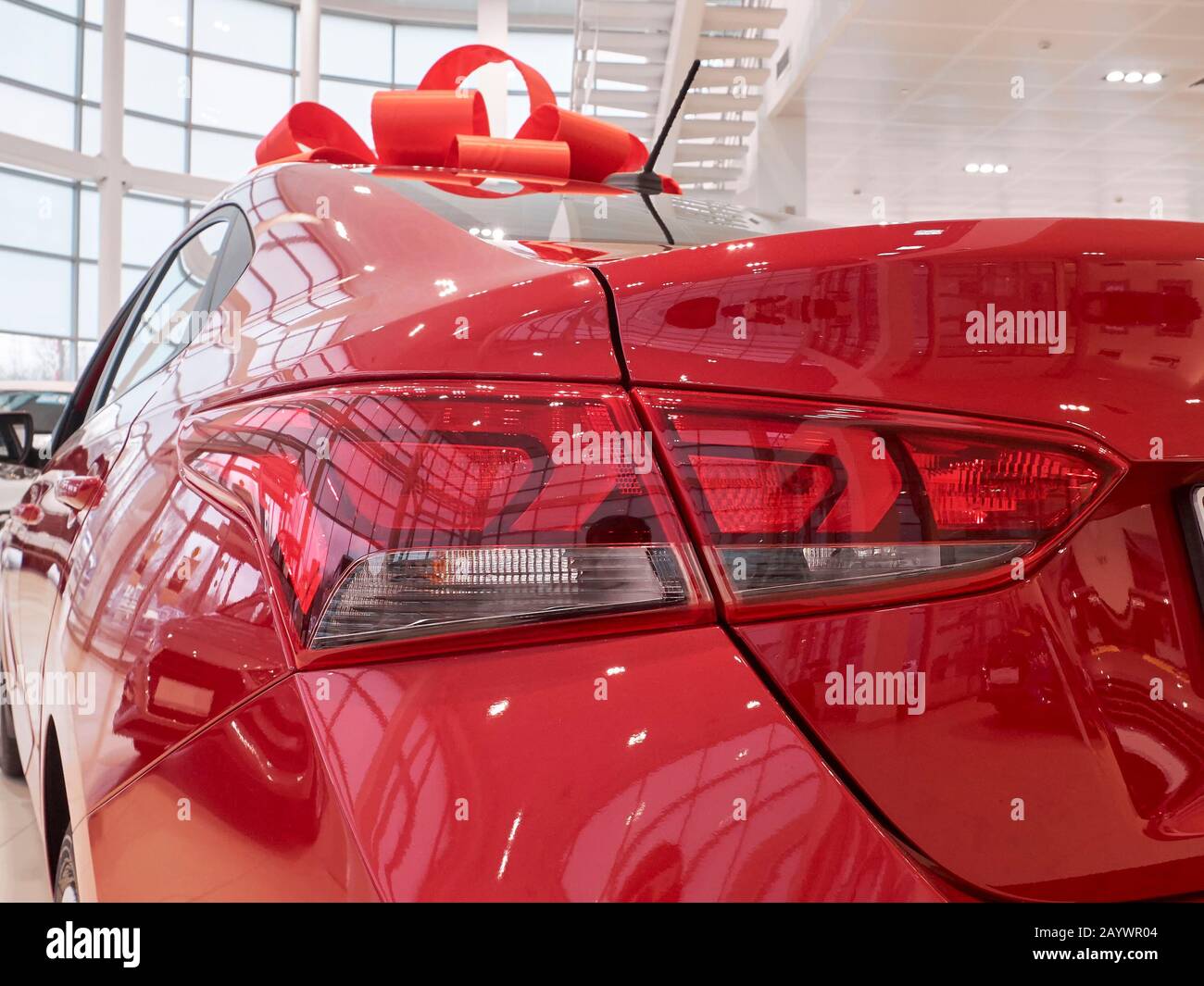 Neues rotes Auto mit rotem Geschenkband auf der Rückseite des