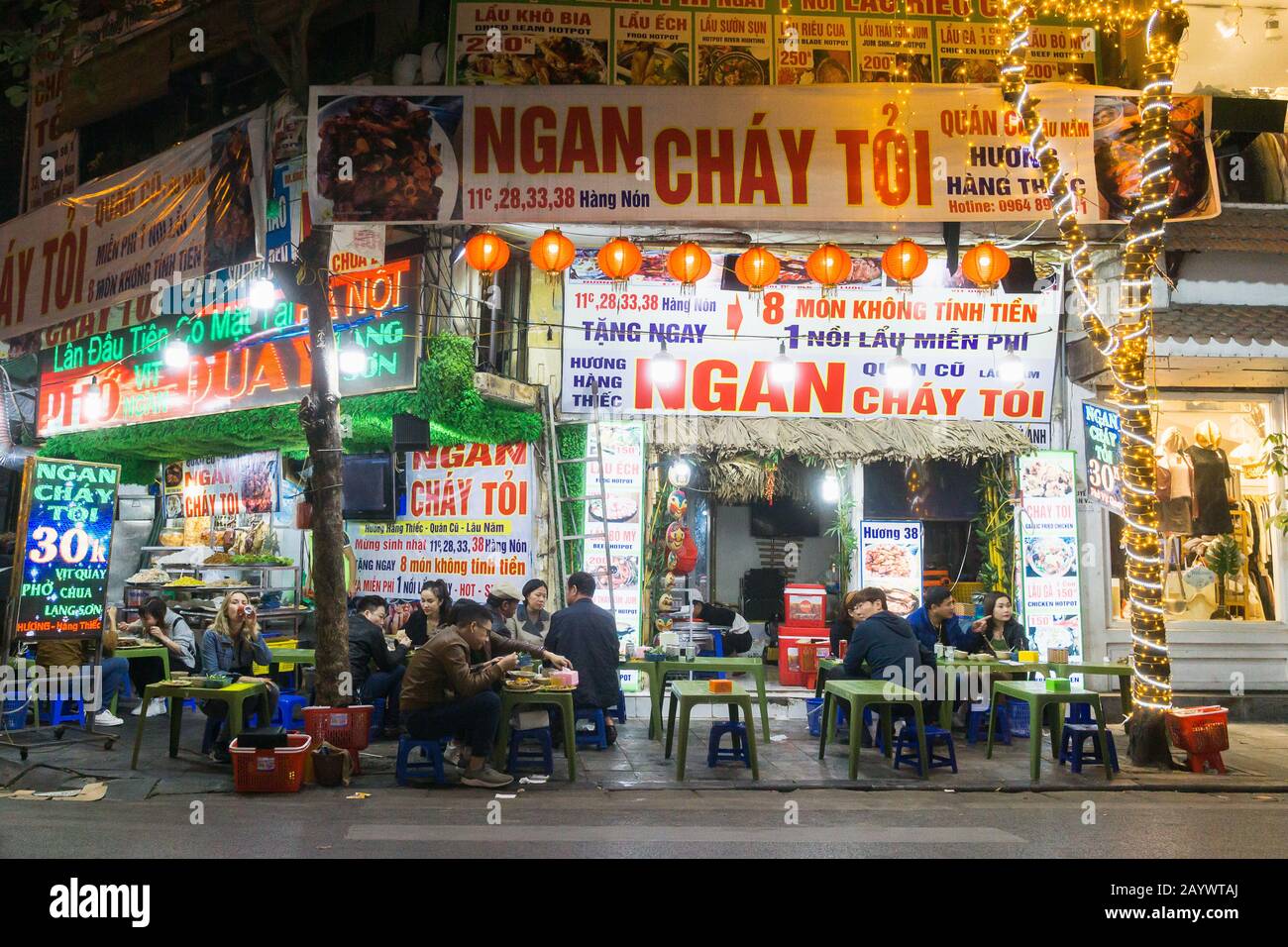 Hanoi Street Food - Menschen, die auf Plastikhocker in der Altstadt von Hanoi, Vietnam, Südostasien zu Abend essen. Stockfoto