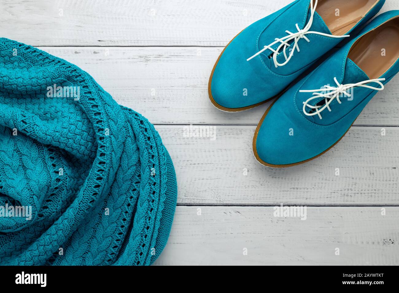 Ein Paar Frauen mit niedrigem Schuh und blauem Pullover auf hellem Holzhintergrund. Flaches Lay, moderne Trends der Modebekleidung. Draufsicht. Lässiges Style-Konzept Stockfoto