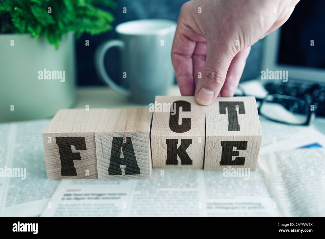 Fake oder FAKT auf Holzblöcken auf Zeitung, echte Nachrichten oder falsches Nachrichtenkonzept Stockfoto