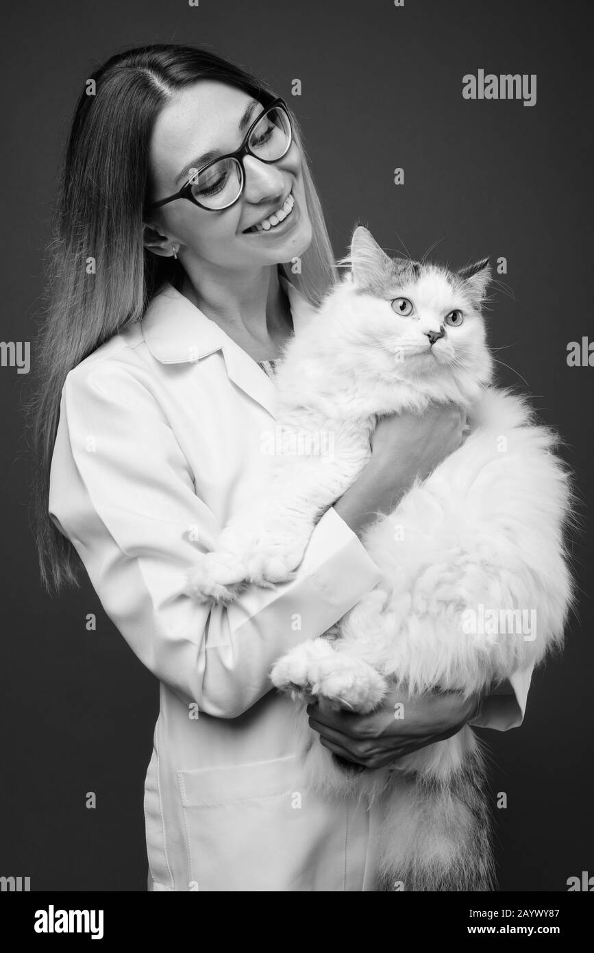 Studio shot der jungen schönen Frau Doktor gegen grauer Hintergrund Stockfoto