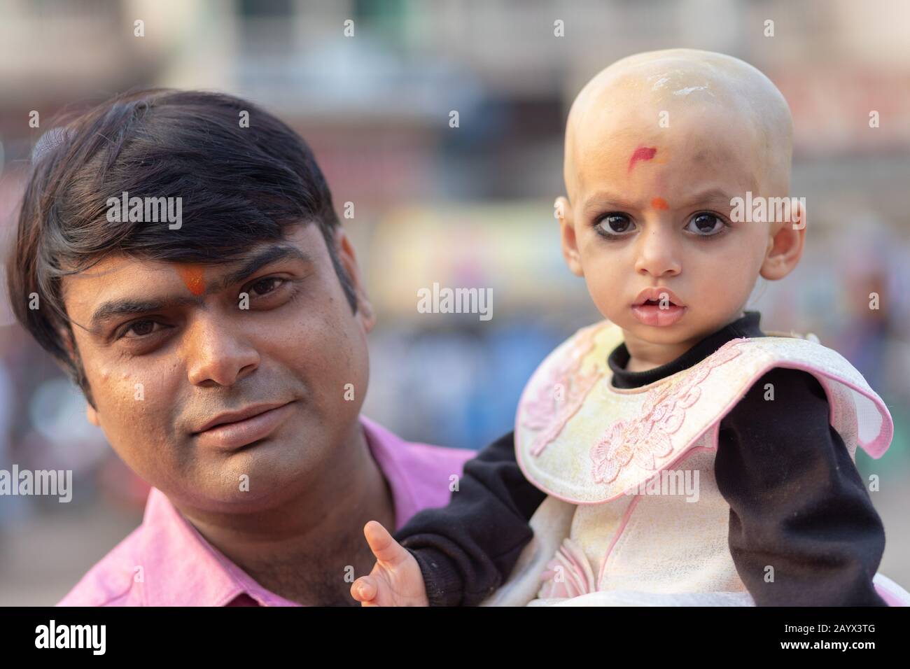 Puri, INDIEN, 13. Januar 2019: EIN fröhlicher Vater und sein kleiner Taugether posieren in den Straßen von Puri in Indien Stockfoto