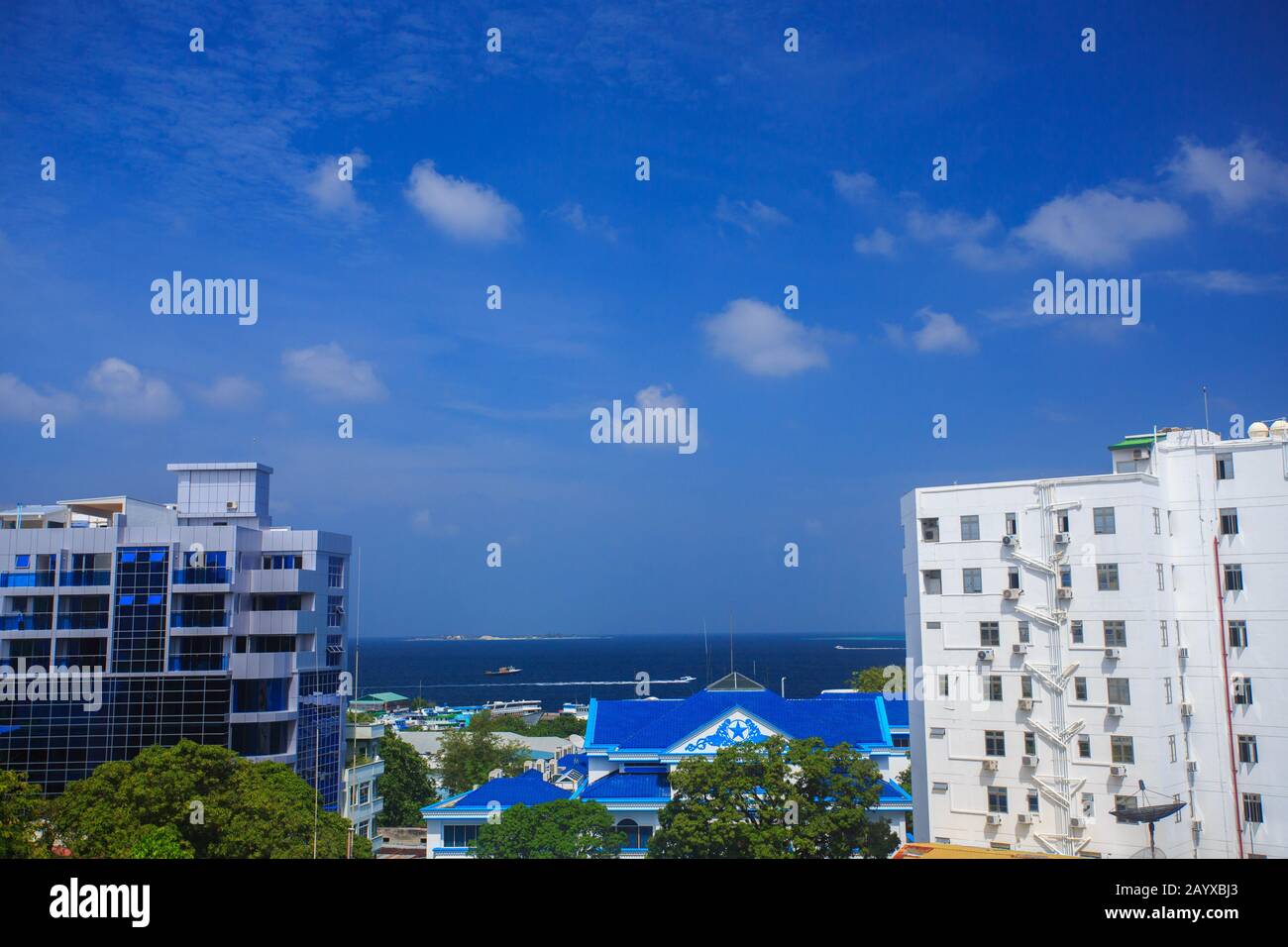 Mehrstöckige Gebäude von Male City (Malediven). Blaues Wasser des Indischen Ozeans ist in einer Entfernung sichtbar. Stockfoto