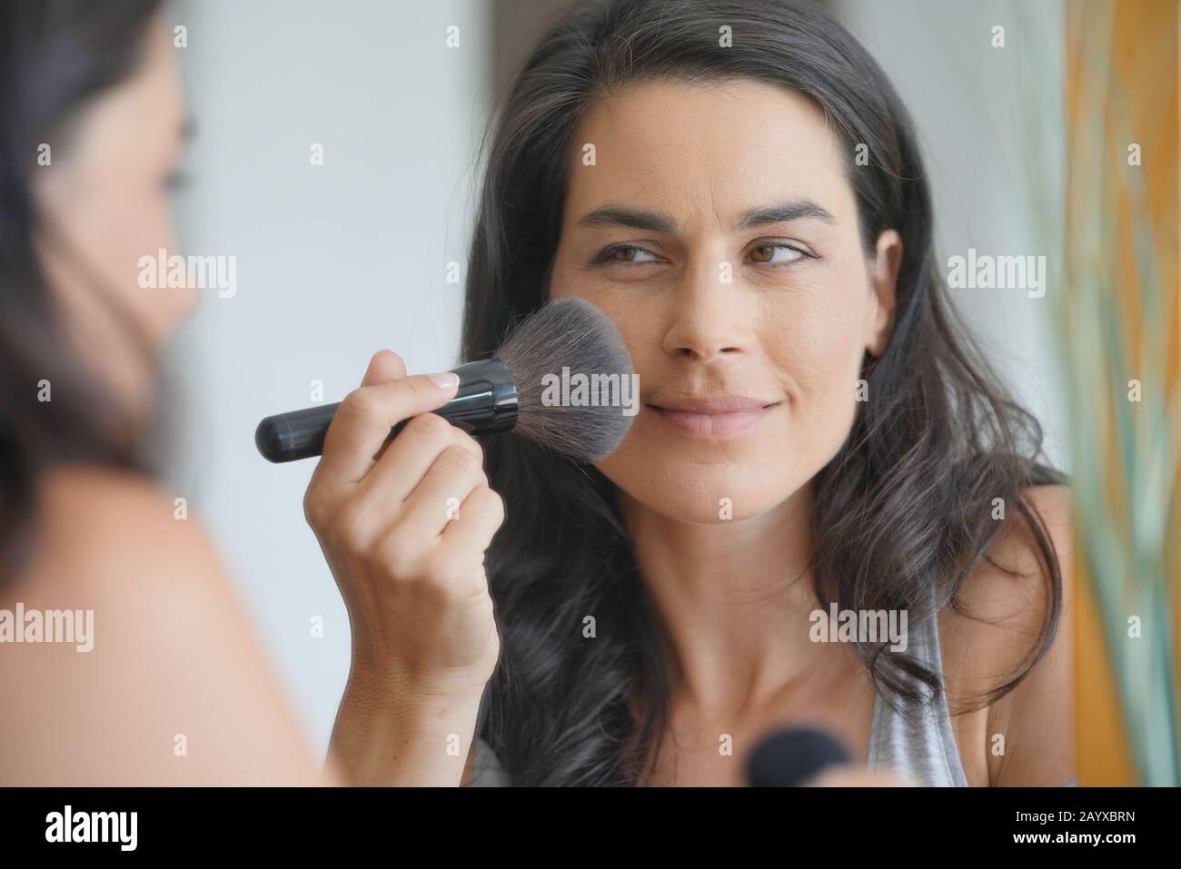 Portrait der Brunette-Frau, die Make-up aufsetzt Stockfoto