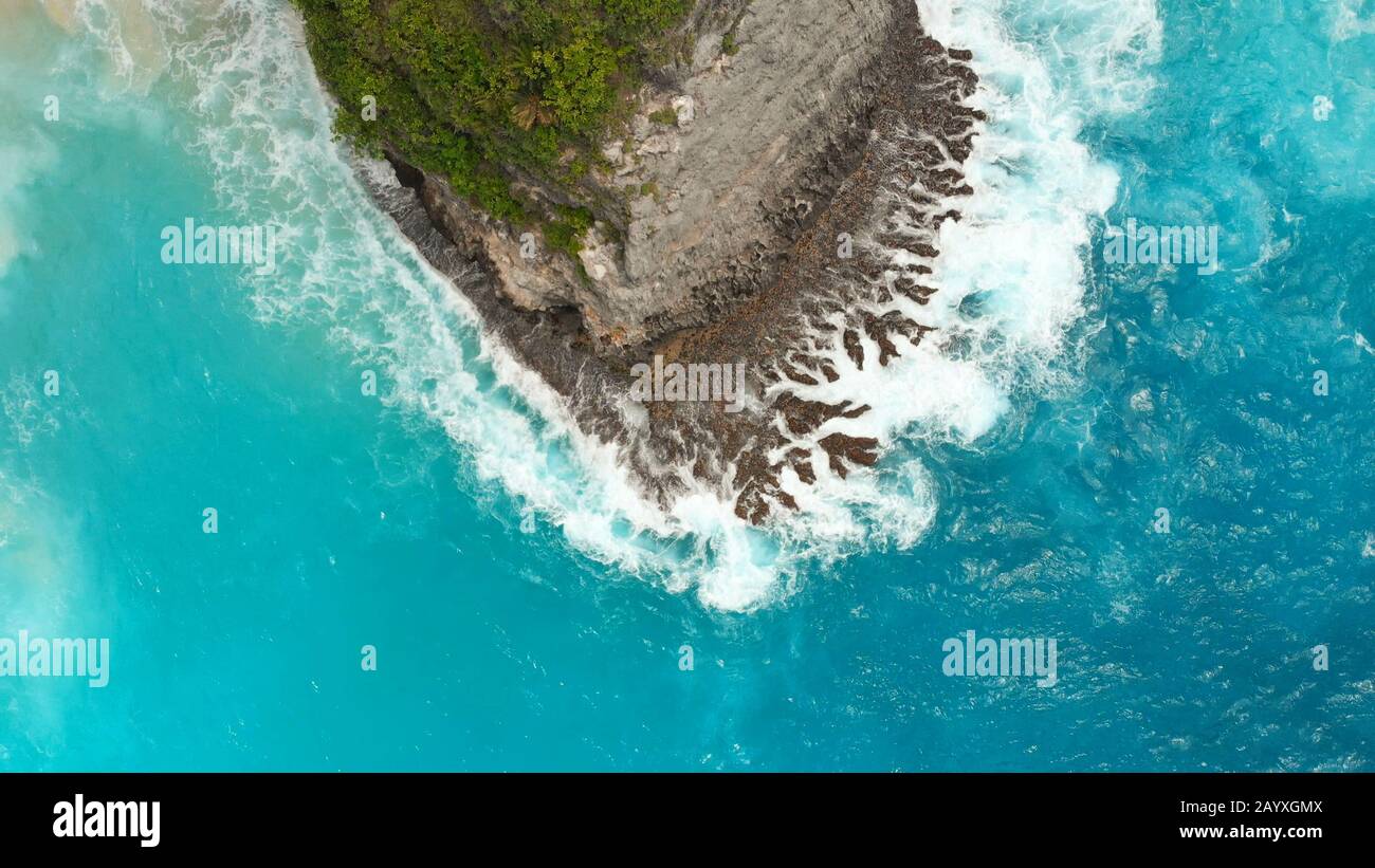 Weiß-blaue Wellen schlagen auf den Felsen der Insel Nusa Penida nahe dem Kelingking-Strand. Stockfoto