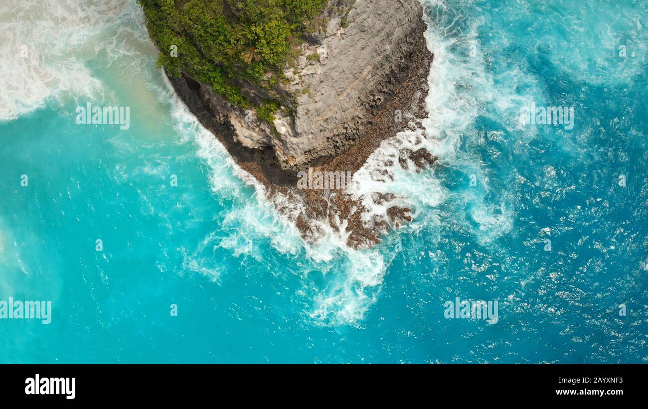 Weiß-blaue Wellen schlagen auf den Felsen der Insel Nusa Penida nahe dem Kelingking-Strand. Stockfoto