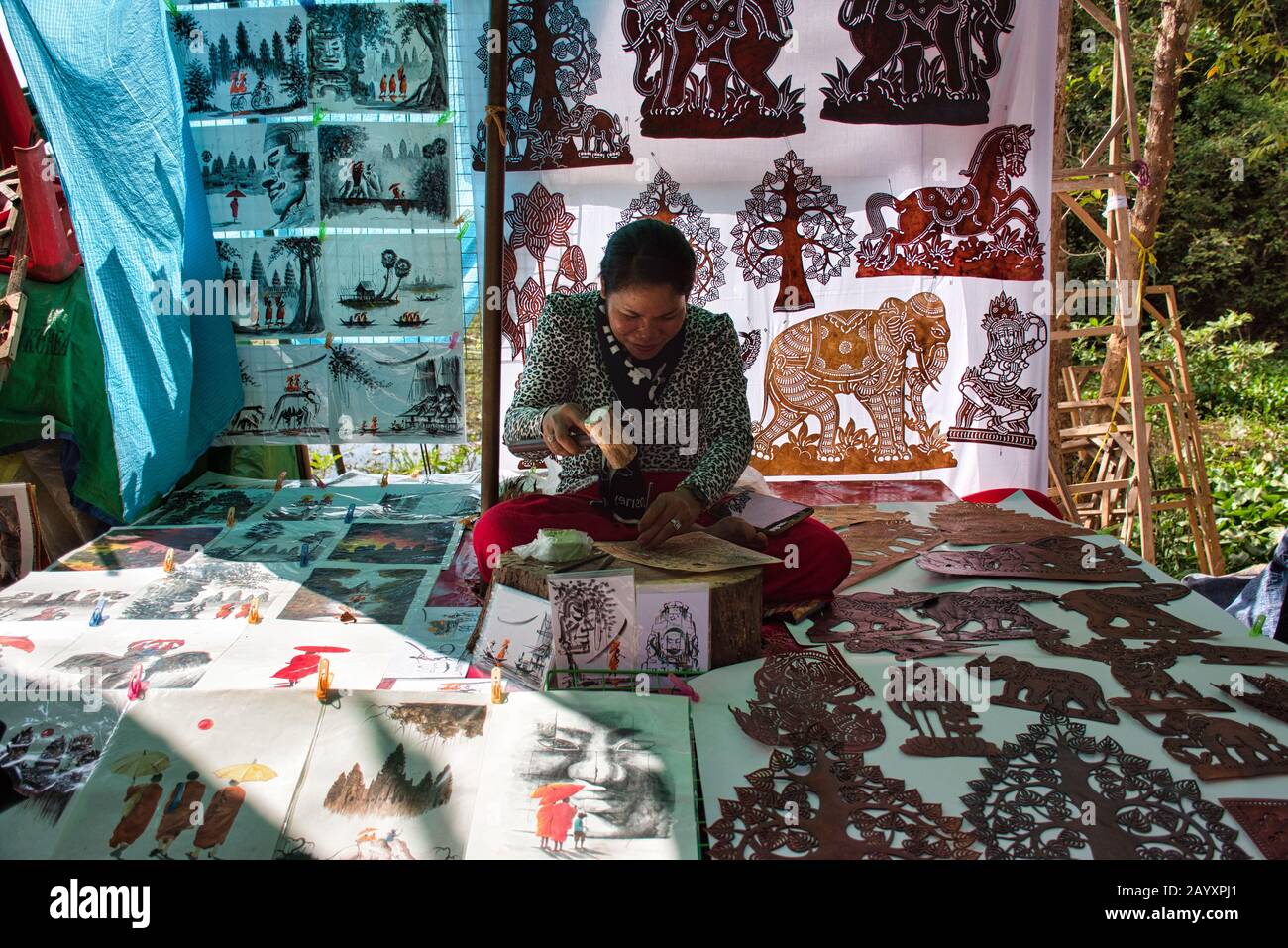 Siem Reap, Kambodscha - 15. Februar 2020: Eine kambodische Frau sitzt und bereitet bunte, traditionelle handgefertigte Bilder mit khmer-motiven vor Stockfoto