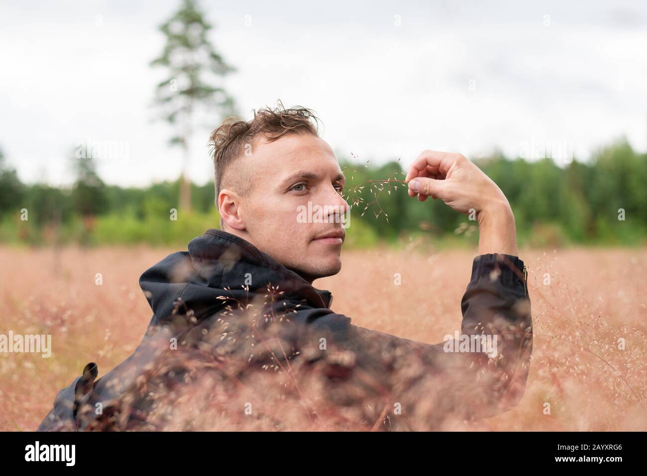 Der Mann sitzt auf einem dicken Feld und denkt. Stockfoto