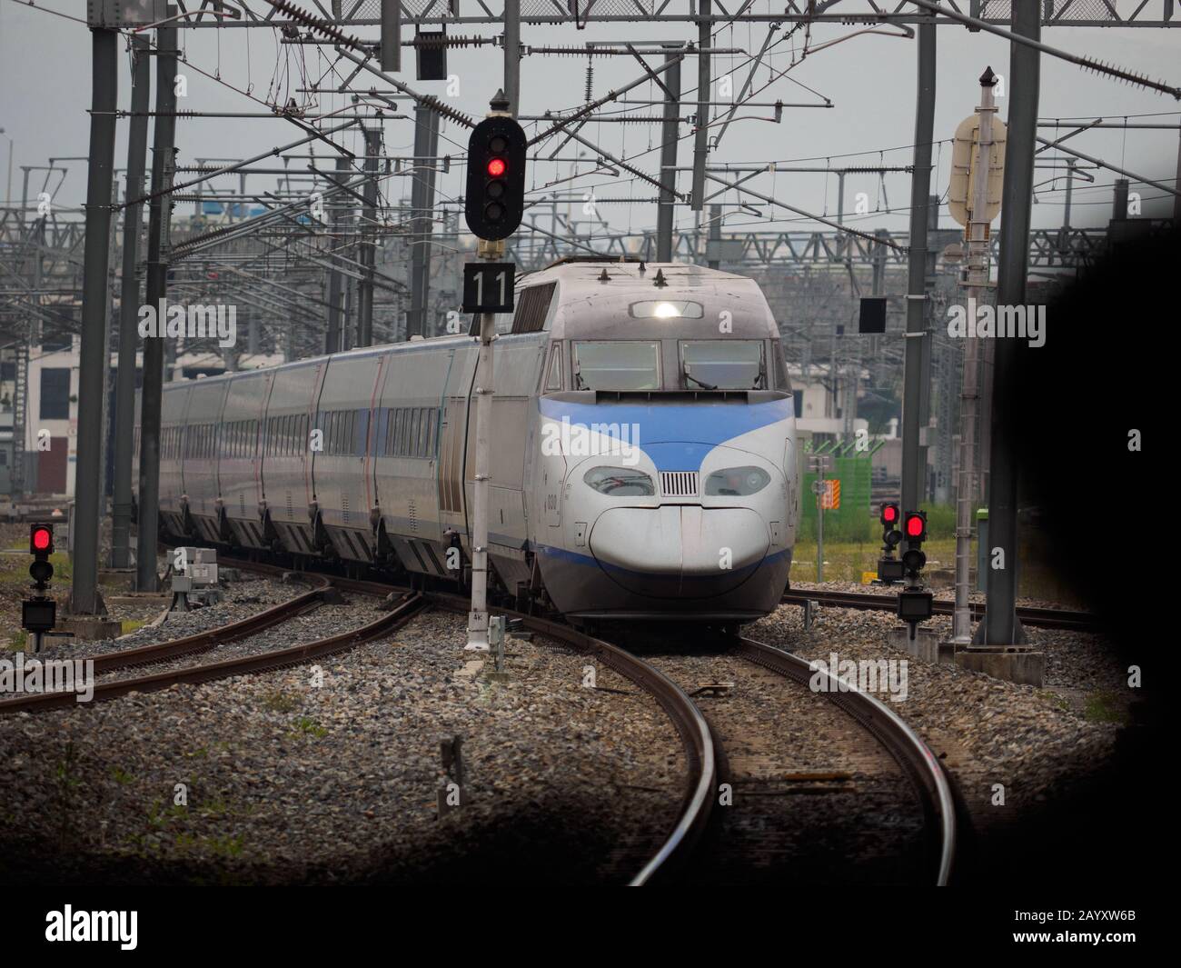Passenger Silhouette, wartet auf einen koreanischen KTX-Einschusszug, während er in den Bahnhof zieht. Stockfoto