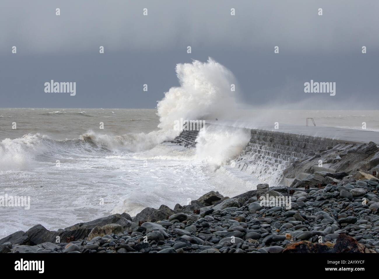 Die Sturmwinde, die über 60mph Uhr stürmen, und die morgendliche Flut verbinden sich und bringen riesige Wellen über die Irische See, um Aberystwyth zu schlagen. Stockfoto