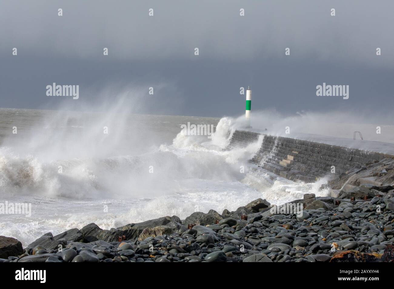 Die Sturmwinde, die über 60mph Uhr stürmen, und die morgendliche Flut verbinden sich und bringen riesige Wellen über die Irische See, um Aberystwyth zu schlagen. Stockfoto